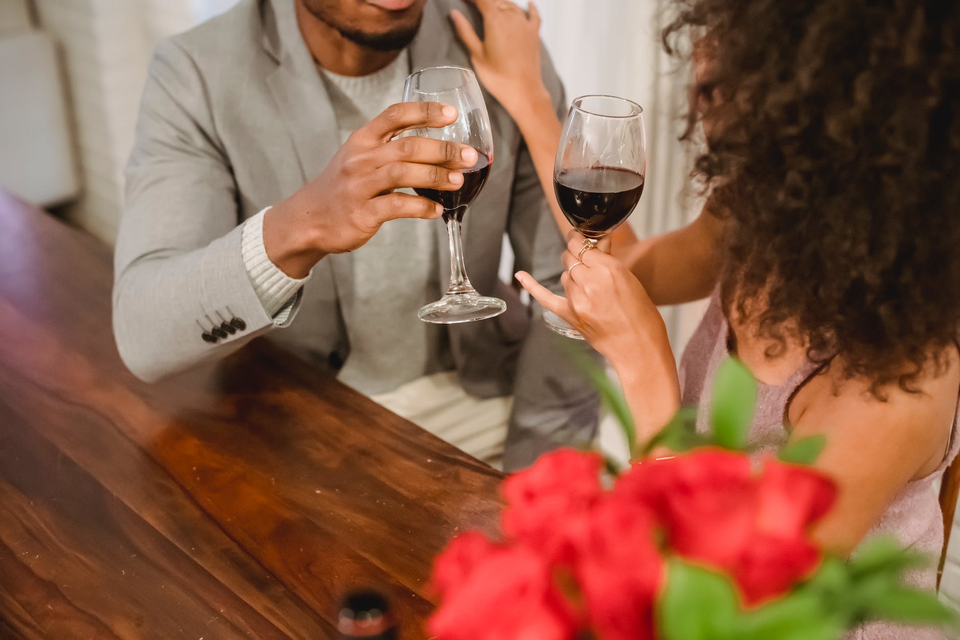 faceless african american couple while drinking wine at table