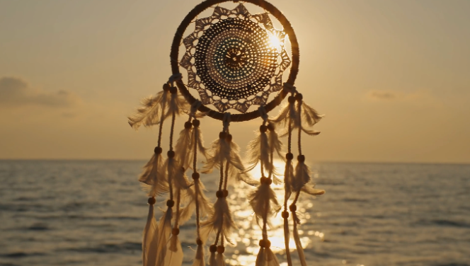 dream catcher blocking the sun with ocean horizon in the background